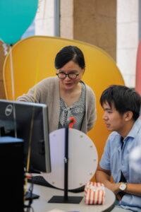 Yi Liu showing a participant how to revise their generative AI prompts.