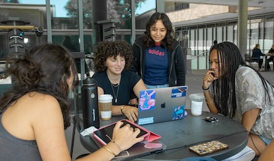 Students sit around table talking